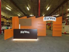 Custom Laminated Inline Exhibit with LED Accent Lights, Halo Lit Logo Sign, Shelves, Pony Wall, Monitor Mount, and Custom Counter with Open Back and Shelves